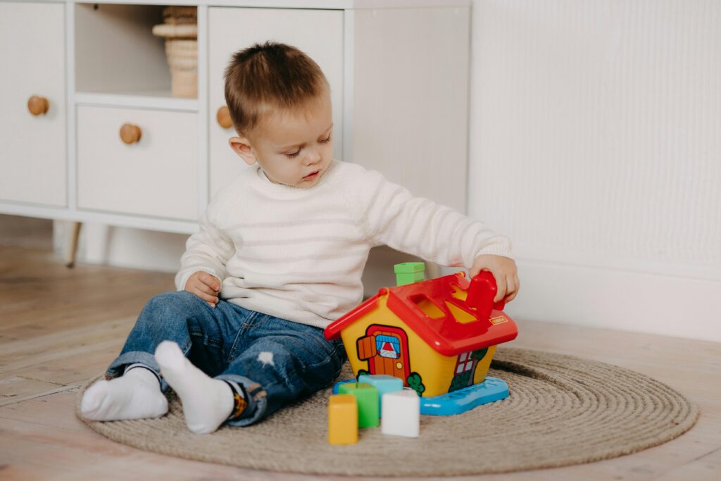 Young boy engages with colorful educational toy inside a cozy home environment.
